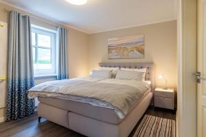 a bedroom with a large bed and a window at Hardina 1 in Wyk auf Föhr