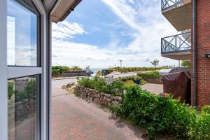 a view from the window of a house with a brick sidewalk at Hardina 1 in Wyk auf Föhr