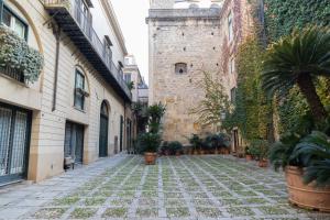 een steegje met potplanten en een gebouw bij Dimora Artale Suite in Palermo