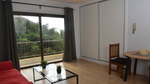 a living room with a red couch and a large window at Apt El Molino 2B in Valle Gran Rey