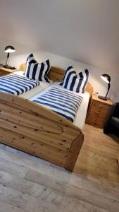 a bedroom with two beds with blue and white striped pillows at Ferienhaus Kleine Möwe in Altfunnixsiel +10 photos