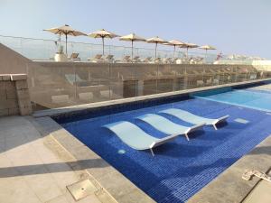 a swimming pool with lounge chairs and umbrellas at IL MONTE Galala -families only- المونت جلالة in Ain Sokhna
