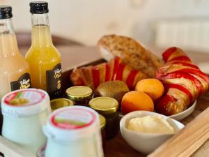 a tray of food with bread and fruit and drinks at VINEÀ Suite in Angé
