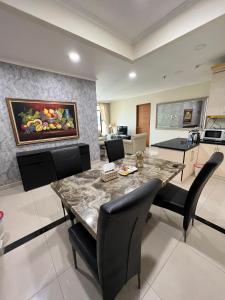 a kitchen and dining room with a table and chairs at Spacious living room Hampton's Park Apartment in Jakarta