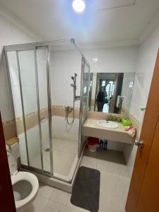 a bathroom with a shower and a toilet and a sink at Spacious living room Hampton's Park Apartment in Jakarta