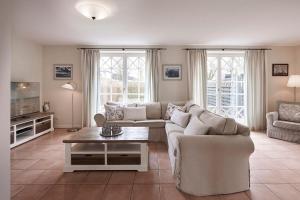 a living room with a couch and a tv at Hüs Godewind in Alkersum