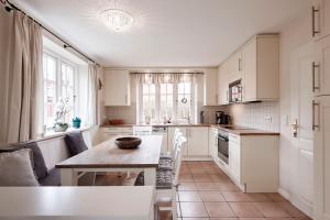 a kitchen with white cabinets and a table at Hüs Godewind in Alkersum