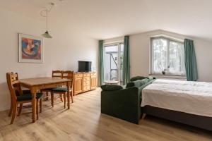 a bedroom with a bed and a table and a dining room at Residenz Dünenstraße Ferienwohnung 19 in Binz