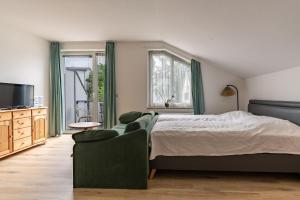 a bedroom with a bed and a couch and a television at Residenz Dünenstraße Ferienwohnung 19 in Binz