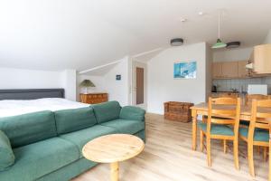 a living room and kitchen with a green couch and a table at Residenz Dünenstraße Ferienwohnung 19 in Binz