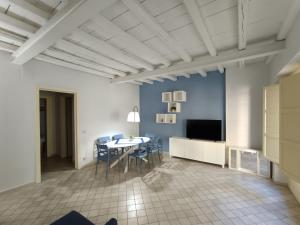 een woonkamer met een tafel en stoelen en een televisie bij Dimora Artale Suite in Palermo