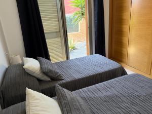 two beds in a room with a window at Fuerteventura Velvet Golf in Antigua +33 photos