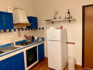 a kitchen with blue cabinets and a white refrigerator at Al Duomo in Ronciglione