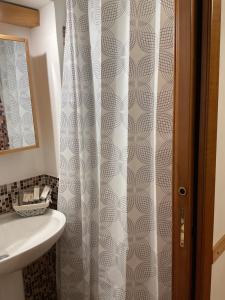 a bathroom with a shower curtain and a sink at Al Duomo in Ronciglione +28 photos