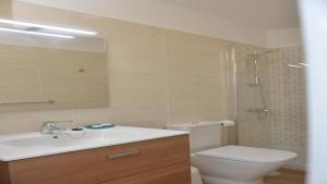 een badkamer met een toilet, een wastafel en een spiegel bij Apt El Molino 3B in Valle Gran Rey