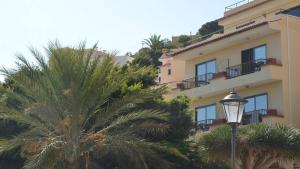 een geel gebouw met palmbomen en een straatlicht bij Apt El Molino 3B in Valle Gran Rey