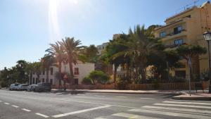 een stadsstraat met palmbomen en een gebouw bij Apt El Molino 3B in Valle Gran Rey +5 foto's