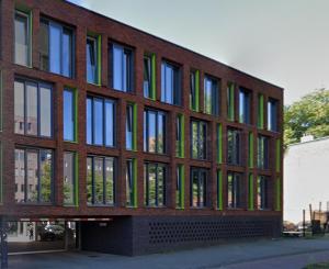 a brick building with green and blue windows at Apartment 4G in Amersfoort