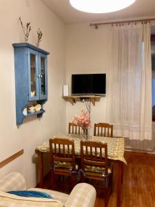 a living room with a table with chairs and a tv at Al Duomo in Ronciglione
