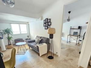 a living room with a couch and a table at Le Beffroi de Gaston Climatisé in Aix-en-Provence