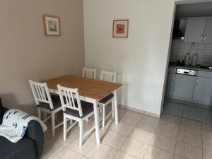 a kitchen with a wooden table and four chairs at UG-Buche in Göhren-Lebbin