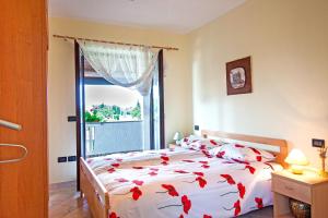 a bedroom with a bed with red flowers on it at Apartman Orbanići in Orbanići