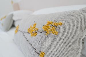 a close up of a pillow with yellow flowers on it at Feel Boutique Rooms in Oristano