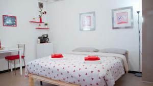 una camera da letto con un letto con asciugamani rossi di Studio-Sleeps 2-AirCon-Town Centre-Free Parking a Montagnana Altre 2 foto