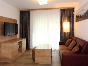 ein Wohnzimmer mit Couch und Fernseher in der Unterkunft H&P Touristik Residenz Grafenmatt GRA-3-2 in Feldberg