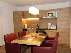 eine Küche mit einem Holztisch und Stühlen in der Unterkunft H&P Touristik Residenz Grafenmatt GRA-3-2 in Feldberg