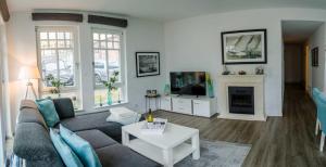 ein Wohnzimmer mit Couch und Fernseher in der Unterkunft Westendpalais 04 Strandburg in Ahlbeck + 6 Fotos