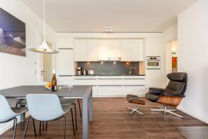 Una cocina y un comedor con mesa y sillas. en Quartier 7 App 10, en Ahlbeck