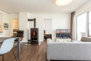 una sala de estar con un sofá y una chimenea en Quartier 7 App 10, en Ahlbeck 17 fotos más