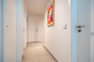 a hallway with white walls and a painting on the wall at Seeresidenz Haus Atlantic, App C02 in Bansin +12 photos