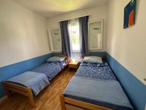 a room with three beds in it with a window at House Neli in Srednje Selo na Šolti