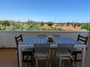una mesa azul y sillas en el balcón en Villa Anna, en Savelletri di Fasano