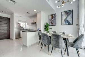 a kitchen and dining room with a table and chairs at PVH - Chic 3BR Villa with Backyard - Albizia in Dubai +28 photos