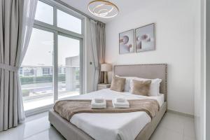 a white bedroom with a large bed and a window at PVH - Chic 3BR Villa with Backyard - Albizia in Dubai