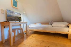 Posto letto in camera con scrivania e letto Sidx Sidx Sidx. di Haushaelfte Pigead s Cove ID 428 a Tönning