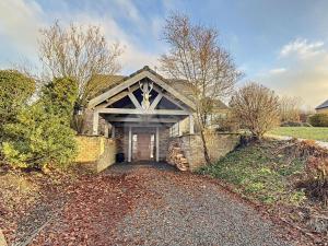 a stone house with a driveway leading to the front door at La cabane du Cerf in Stavelot
