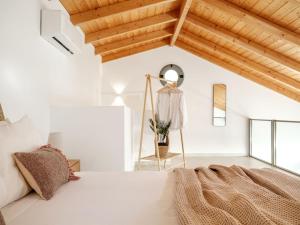 a white room with a bed and a mirror at Alýria Sea Side Suites in Agios Nikolaos +29 photos
