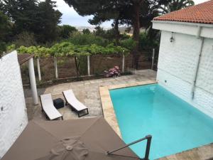 a swimming pool with an umbrella and two chairs at Finca Fuente Laurel in Arucas