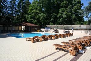 una fila de bancos de madera junto a una piscina en Hotel Gloria Palace Diplomat en Sofía