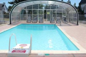 a swimming pool with chairs and a gazebo at Camping 3 étoiles - Piscine - ccbb0be in Ambon +6 photos