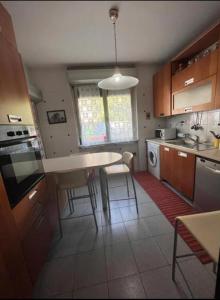 Una cocina con una mesa y sillas y una mesa y una cocina con una estufa. en Casa vacanze Lorien, en Génova