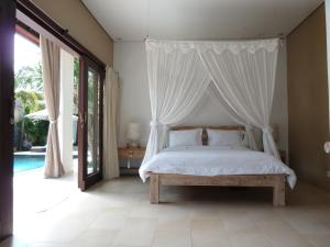 a bedroom with a bed with a canopy at La Dolce Villa in Seminyak