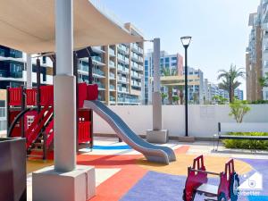 Un parque infantil con un tobogán en un edificio. en Amazing Studio in Meydan l Pool , Gym & Balcony, en Dubái