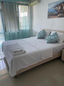 a bedroom with a large bed with white sheets and pillows at M&V House in Balchik +3 photos