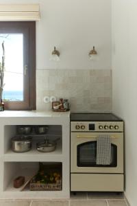 a kitchen with a stove and a window at The Light House Chorefto in Chorefto +20 photos