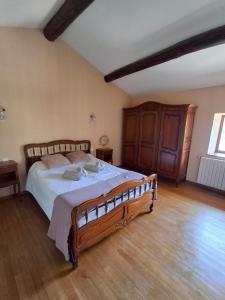 a bedroom with a large bed and a wooden floor at Gite Familial aux portes de Foix "Le Coulhòu"- Ariège- 6 personnes in Ferrières-sur-Ariège